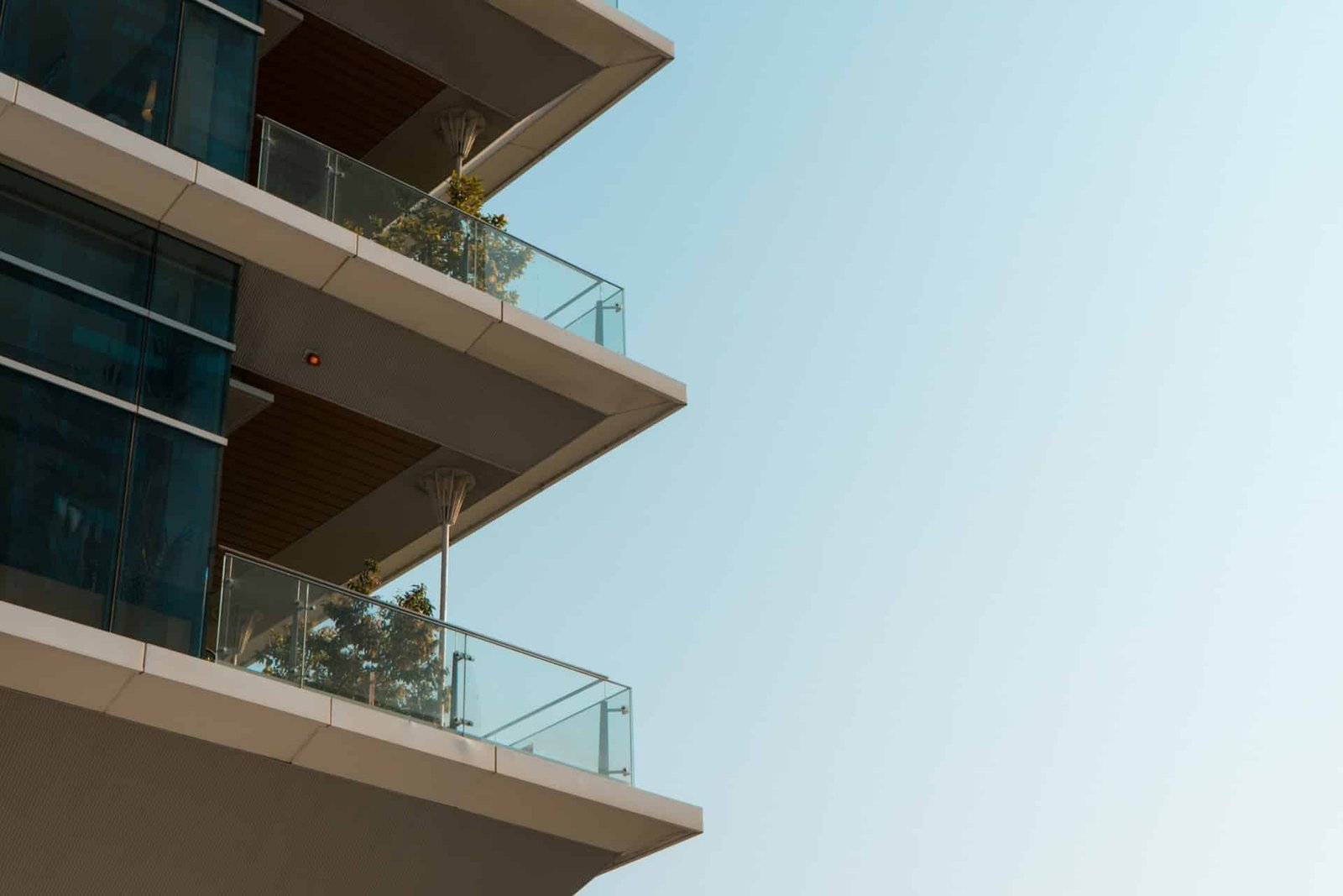 Hand entfernt Laub aus einem Balkonablauf